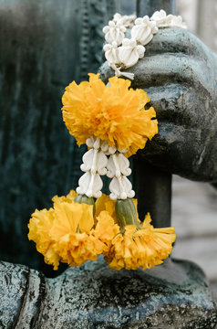 Statue of Buddha with flowers in a Thai temple