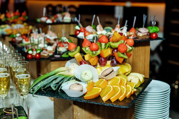 Fresh juicy fruits beautifully lay on a black tray