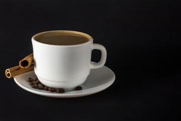 White cup of hot coffee and Cinnamon sticks isolated on black background.