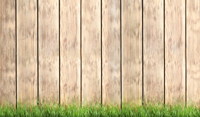 Fresh green grass against wooden background, space for text