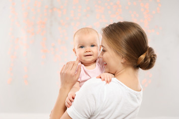Portrait of happy mother with her baby against blurred lights
