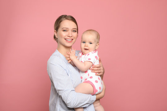 Portrait of happy mother with her baby on color background