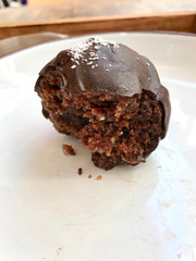 Chocolate Truffle Balls with Coconut Powder on Paper with Wooden Tray.