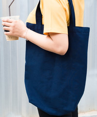 Woman carrying a blue shopping bag mockup