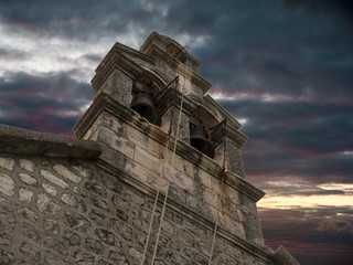 Christian church stone bell tower with sunset background