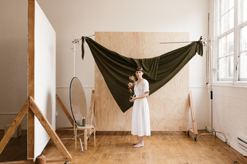 modern creative portrait of brunette woman in front of plywood and fabric backdrops