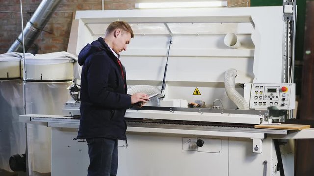 Engineer setting up automatic edge bander machine