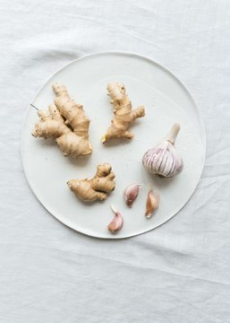Ginger, garlic and spices on ceramic plate with linen tablecloth
