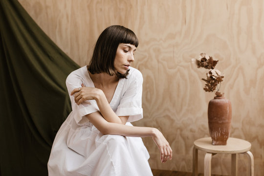 modern creative portrait of brunette woman in front of plywood and fabric backdrops