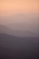 Beautiful sunset with mountains and valleys in different shades of red and orange in Tuscany, Italy
