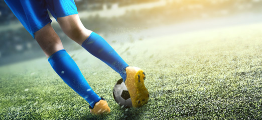 Rear view of football player man kicking the ball