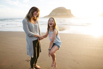 Mom playing with daughter outside.