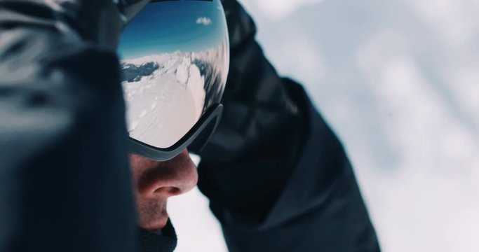 Skier snowboarder putting his glasses outdoors, close up