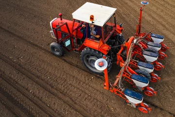 Zelfklevend Fotobehang Aerial view of tractor with mounted seeder performing direct seeding © Bits and Splits