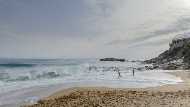 Ni&ntilde;os diviertendose con las olas en  una playa de la Costa Brava, Alt Empord&agrave;, Catalu&ntilde;a, Espa&ntilde;a