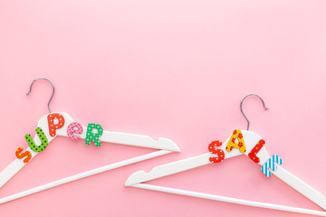 White hangers with sale text on pink background