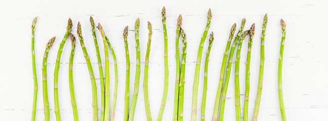 Fresh green asparagus on white wooden background