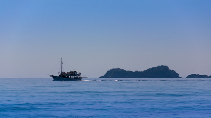 sailing vessel on the Mediterranean Sea, with blue water and rocks seen from afar