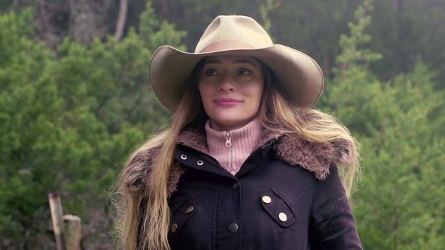 Strong confident female rancher looking around then walking away in slow motion