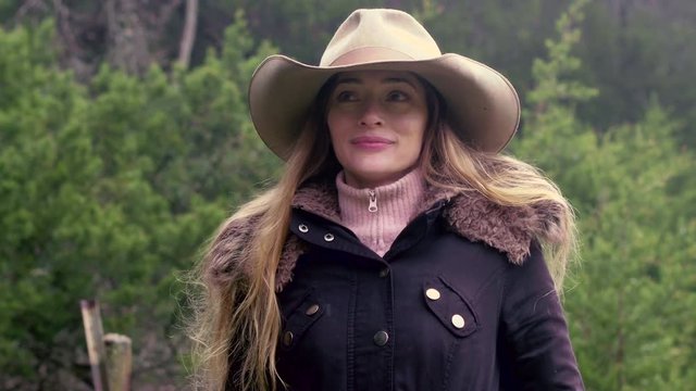 Cowgirl standing over ranch on winter morning with confident expression