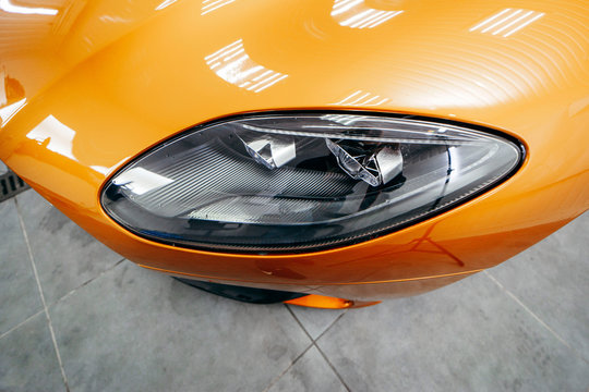 Orange modern car closeup on black background © andrew_shots