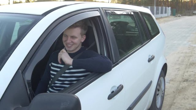 Blonde male millennial driving reverse and using electronic cigarette