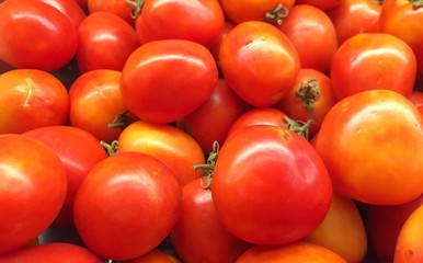 Many red tomatoes are on the shelves in the market, the concept of wallpaper background.