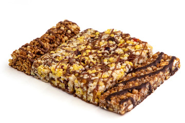vegan dessert: several cereal bars with raisins and honey, isolated on white, short focus