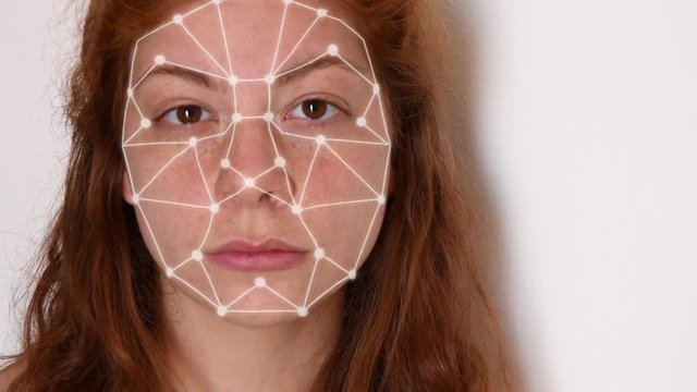 Close up of a young woman with red hair, with a white shirt on a white background, with facial recognition high tech animation with tracking points and a glow effect on her face