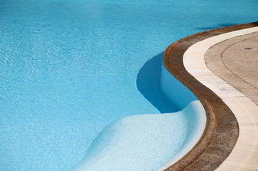 Closeup a part of designed outdoor swimming pool with clear blue water.