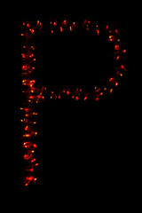 The letter "P" of the English alphabet made of red electric garland on a dark background, blur, bokeh, isolated on black