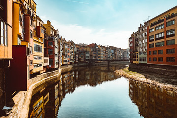 Fototapeta premium Colorful yellow and orange houses and famous house Casa Maso reflected in water river Onyar