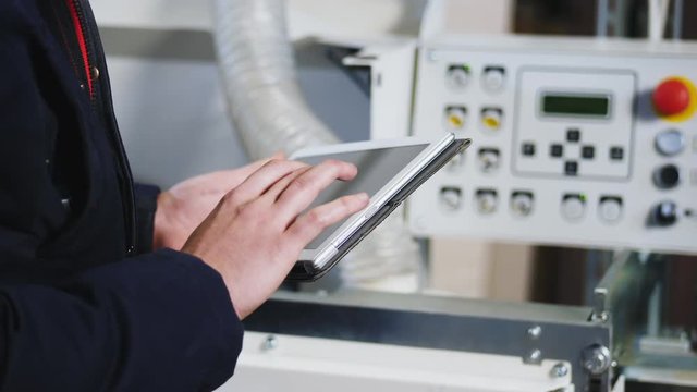 Engineer setting up automatic edge bander machine