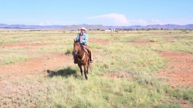 Bearded Rancher Riding Horse Through Old Western Landscape, Towards and Past Frame 4k