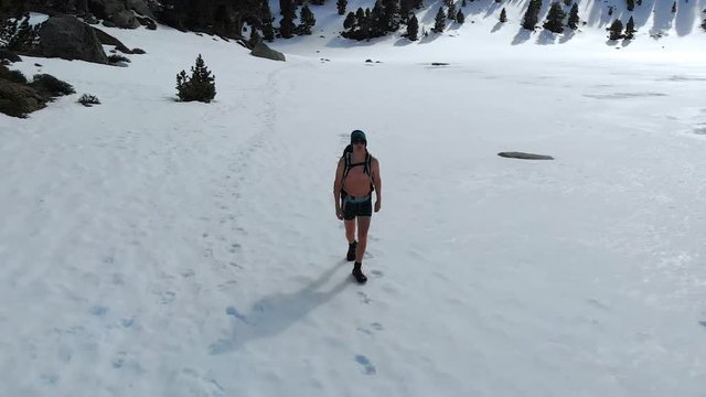 Iceman training cold weather endurance walks over frozen lake with only underwear