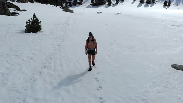 Man walking in frozen landscape, practicing Wim Hof Meditation, Aerial pullback