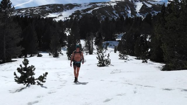 Almost naked man walks over snow landscape in Pyrenees mountain, iceman meditation style yoga