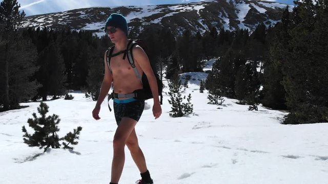 Man almost naked in only briefs walks past frame, Iceman meditation extreme cold conditioning yoga