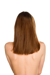 Naklejka premium Back view of young nude woman with long hair on white background
