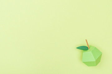 top view of handmade paper apple isolated on green with copy space