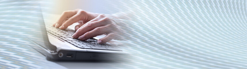 Hands typing on a laptop keyboard, light effect. panoramic banner
