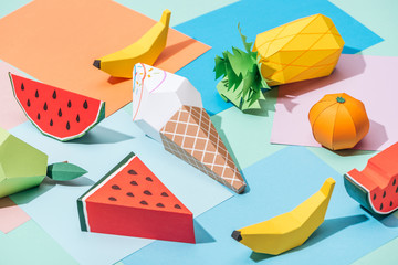 origami ice cream and handmade cardboard fruits on multicolored paper