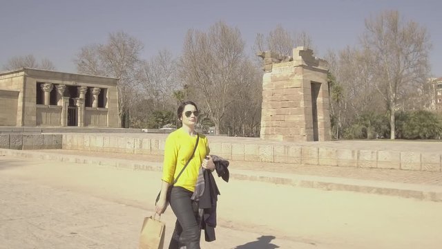 Woman in yellow shirt walking in Parque del Oeste, Egyptian temple of Debod, LOG flat