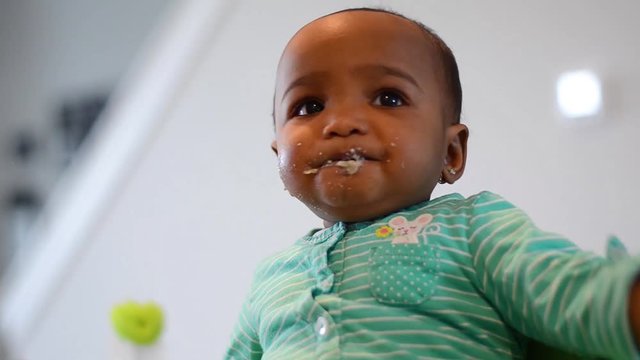 Giving African American baby food in the morning
