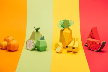 Fotobehang various handmade paper fruits on stripes of colorful paper © LIGHTFIELD STUDIOS