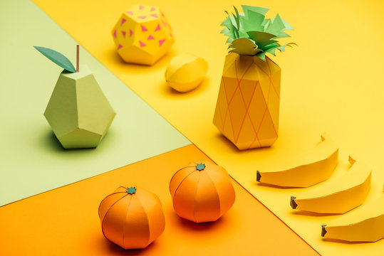 Naklejka various handmade colorful origami fruits on green, yellow and orange paper