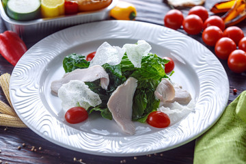 Turkey salad with tomatoes, greens and Chinese chips.