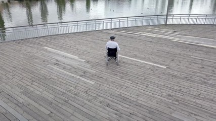 43 year old male sitting on a wheelchair in the park