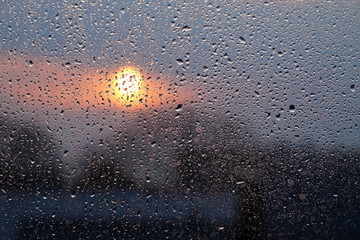 Raindrops on the glass and sunset. Weather forecast.