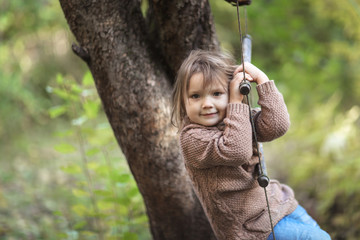 Toddler girl swinging on rope ladder, childhood